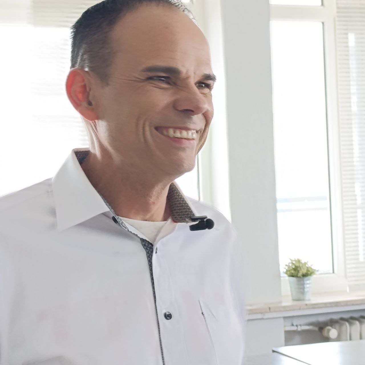 Engelmedium Udo Golfmann in weißem Hemd der einen Vortrag hält.